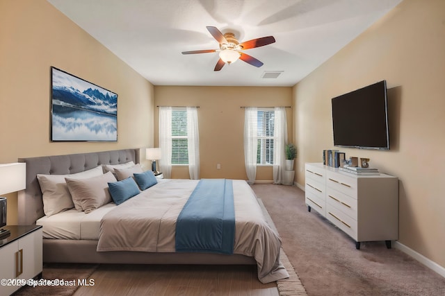 bedroom featuring ceiling fan and light carpet