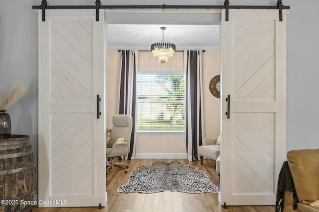 doorway featuring a chandelier, wood-type flooring, and a barn door