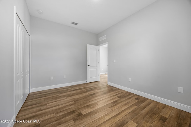 unfurnished bedroom with hardwood / wood-style floors and a closet