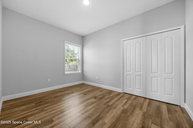 unfurnished bedroom with hardwood / wood-style floors and a closet