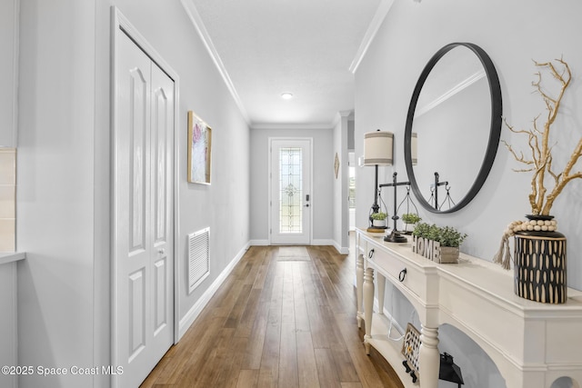 entrance foyer with ornamental molding and hardwood / wood-style flooring