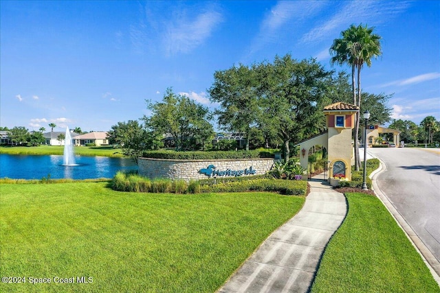 view of home's community featuring a water view and a lawn