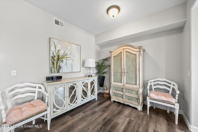 washroom with dark hardwood / wood-style floors, separate washer and dryer, and a textured ceiling