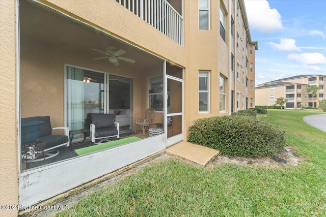 property entrance with ceiling fan and a lawn