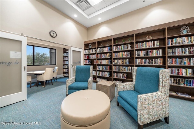 living area with carpet floors and high vaulted ceiling