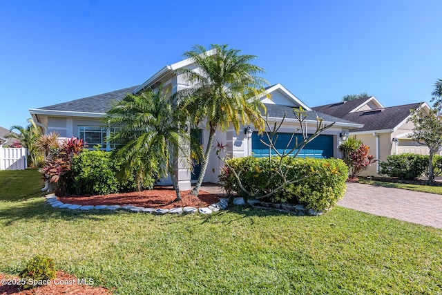 view of property hidden behind natural elements featuring a garage and a front yard