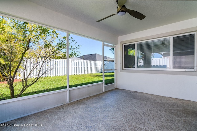 unfurnished sunroom with ceiling fan