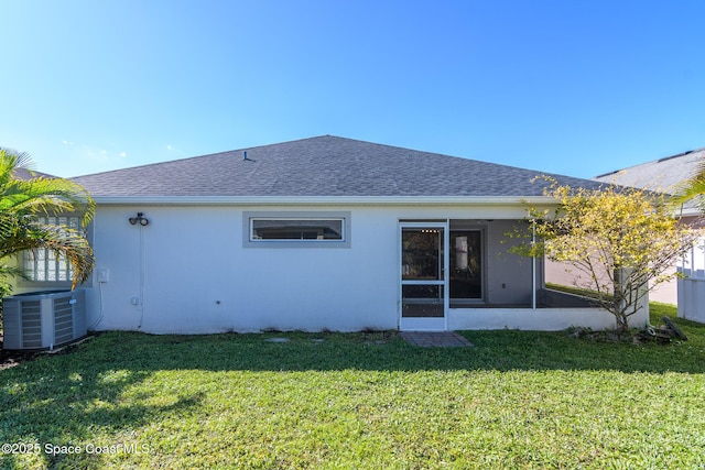 back of property featuring cooling unit, a sunroom, and a lawn