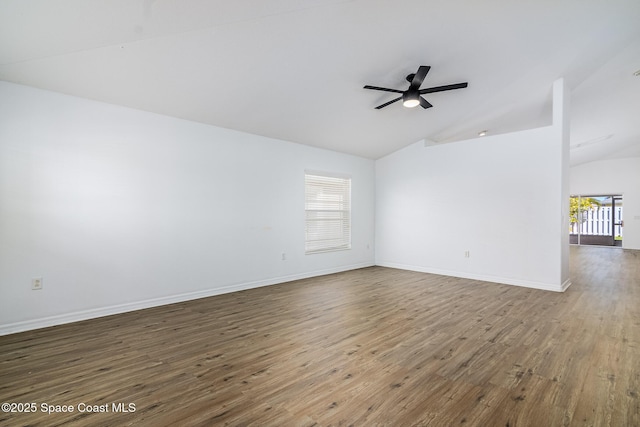 empty room with ceiling fan, vaulted ceiling, and hardwood / wood-style floors