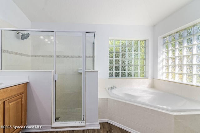 bathroom with vanity, vaulted ceiling, plenty of natural light, and independent shower and bath