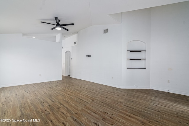 empty room featuring dark wood-type flooring, high vaulted ceiling, and ceiling fan