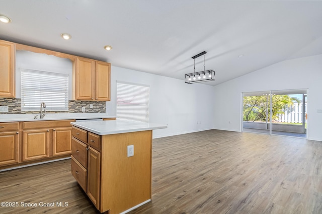 kitchen featuring vaulted ceiling, backsplash, pendant lighting, and a kitchen island