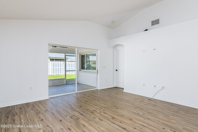 spare room with light wood-type flooring and vaulted ceiling