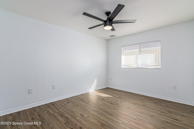 unfurnished room with ceiling fan and dark hardwood / wood-style flooring