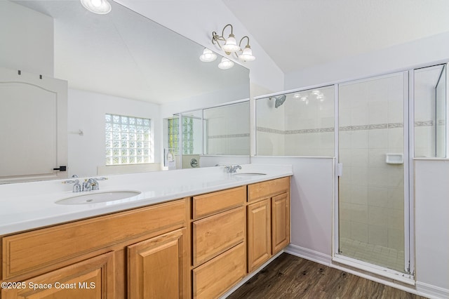 bathroom with a shower with shower door, vanity, wood-type flooring, and lofted ceiling