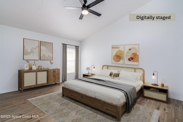 bedroom with ceiling fan, hardwood / wood-style floors, and high vaulted ceiling