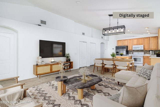 living room with vaulted ceiling and light hardwood / wood-style flooring