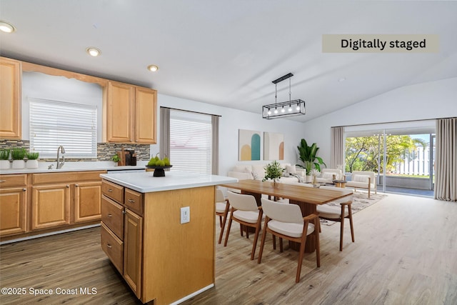 kitchen featuring lofted ceiling, backsplash, pendant lighting, a center island, and dark hardwood / wood-style flooring