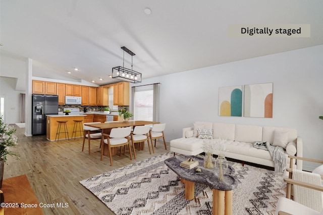 living room with light hardwood / wood-style flooring and lofted ceiling