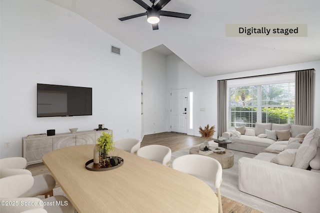 living room with lofted ceiling, wood-type flooring, and ceiling fan