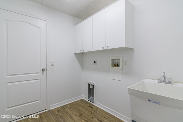 laundry area with hookup for an electric dryer, wood-type flooring, washer hookup, cabinets, and sink