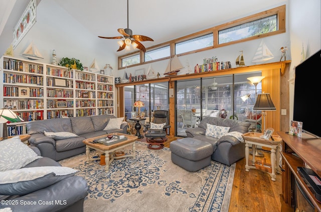 living room featuring ceiling fan, a towering ceiling, and dark hardwood / wood-style floors