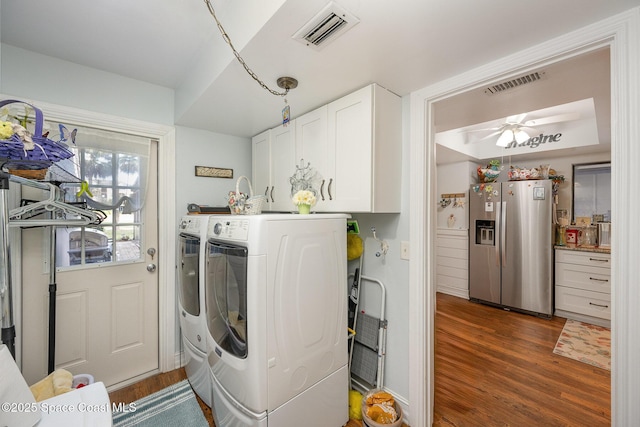 clothes washing area featuring dark hardwood / wood-style flooring, ceiling fan, cabinets, and independent washer and dryer