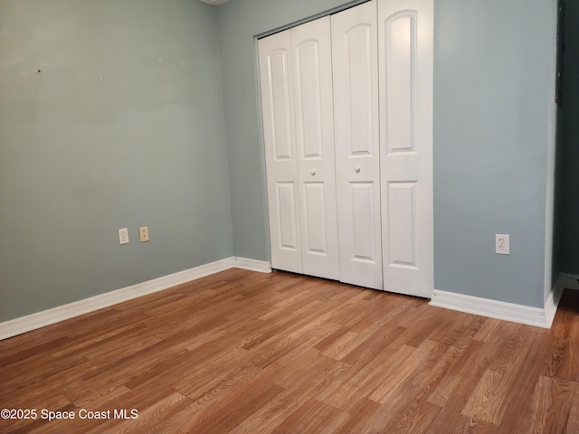 unfurnished bedroom with light hardwood / wood-style flooring and a closet