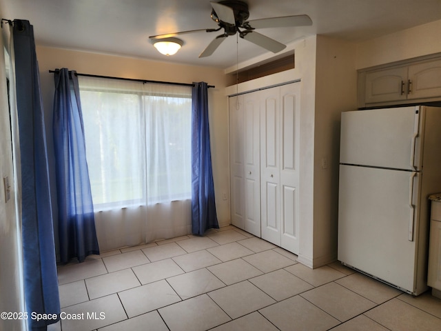 kitchen featuring ceiling fan, white fridge, and light tile patterned flooring