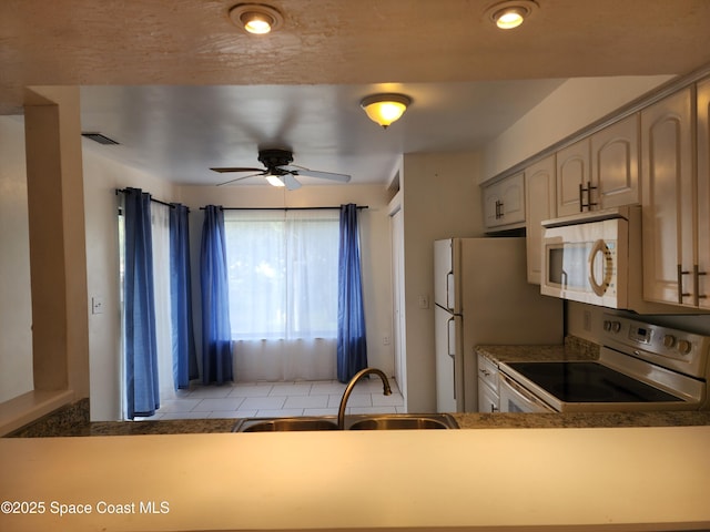 kitchen featuring ceiling fan, sink, and white appliances