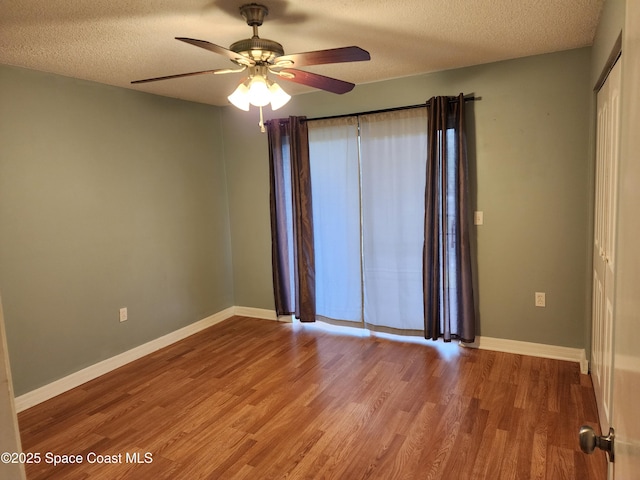 spare room with wood-type flooring, a textured ceiling, and ceiling fan