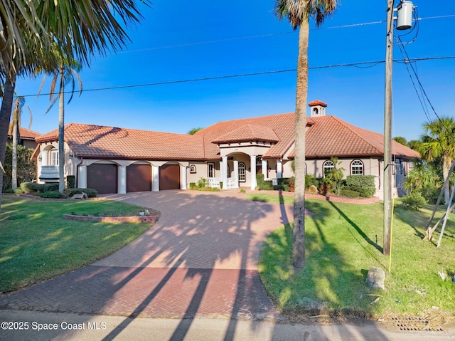 mediterranean / spanish-style house with a garage and a front lawn