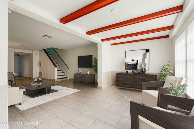 tiled living room featuring beam ceiling and a textured ceiling