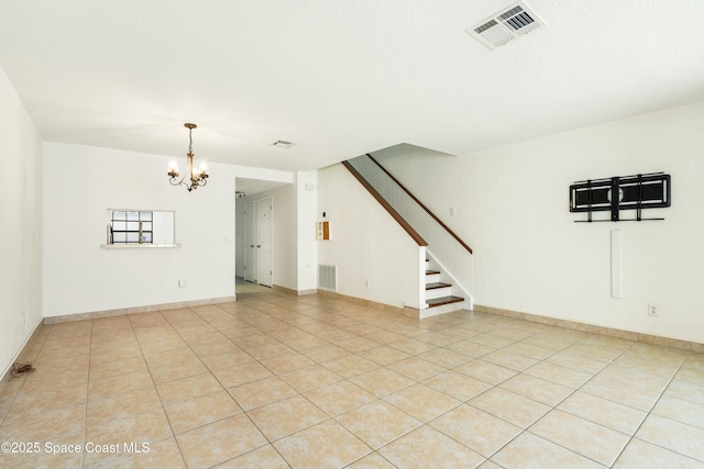 spare room with a chandelier and light tile patterned flooring