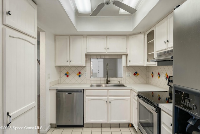 kitchen featuring white cabinetry, sink, a raised ceiling, light tile patterned floors, and appliances with stainless steel finishes