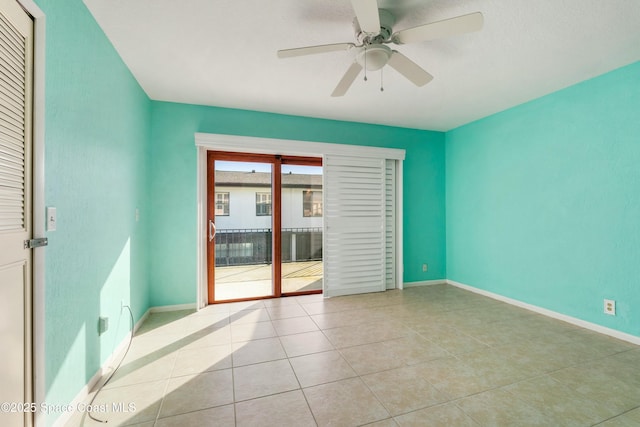 tiled spare room featuring ceiling fan