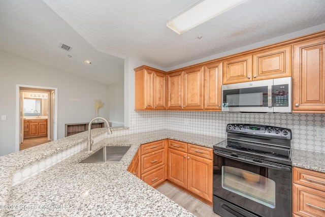 kitchen featuring tasteful backsplash, black range with electric stovetop, light stone countertops, and sink