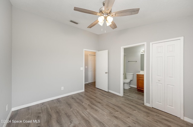 unfurnished bedroom with ensuite bath, light hardwood / wood-style flooring, a closet, and ceiling fan