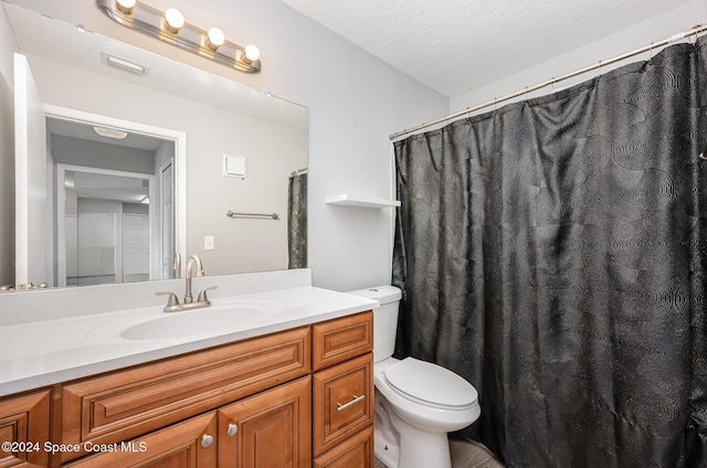 bathroom featuring vanity, toilet, and a textured ceiling