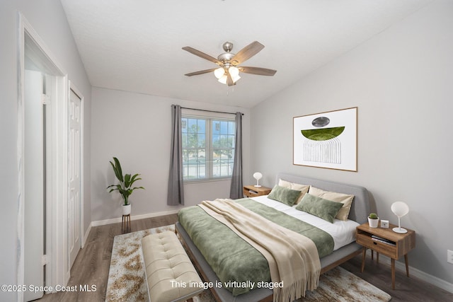 bedroom with ceiling fan, lofted ceiling, and hardwood / wood-style floors