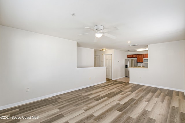 unfurnished living room featuring ceiling fan, light hardwood / wood-style flooring, and sink