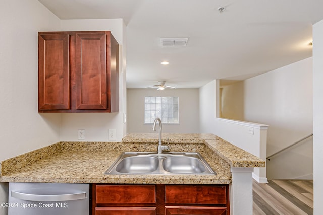 kitchen featuring kitchen peninsula, light wood-type flooring, ceiling fan, sink, and dishwasher