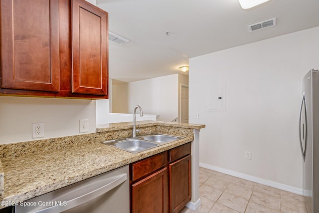 kitchen with light stone counters, sink, light tile patterned floors, and stainless steel appliances