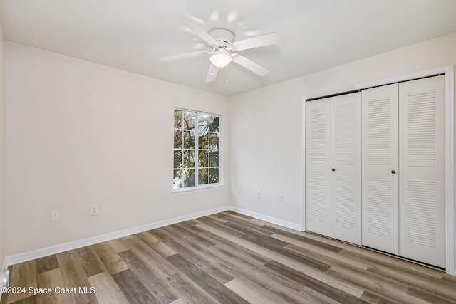 unfurnished bedroom with a closet, light hardwood / wood-style flooring, and ceiling fan