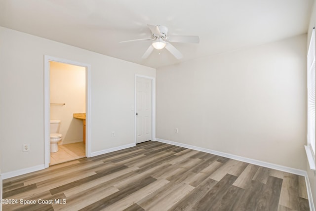 unfurnished bedroom featuring hardwood / wood-style floors, ensuite bathroom, ceiling fan, and a closet