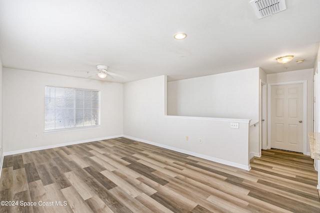 empty room with light wood-type flooring and ceiling fan