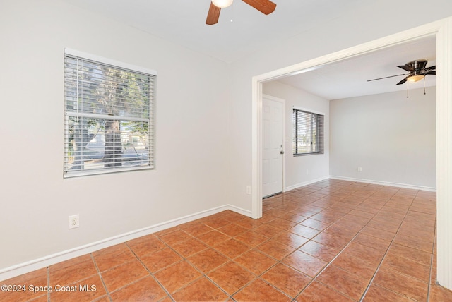 empty room featuring tile patterned flooring, a wealth of natural light, and ceiling fan