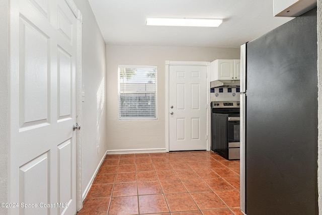 kitchen with white cabinets, appliances with stainless steel finishes, backsplash, and light tile patterned flooring