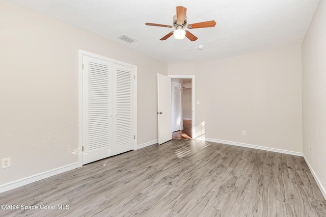 unfurnished bedroom featuring light hardwood / wood-style floors, a closet, and ceiling fan