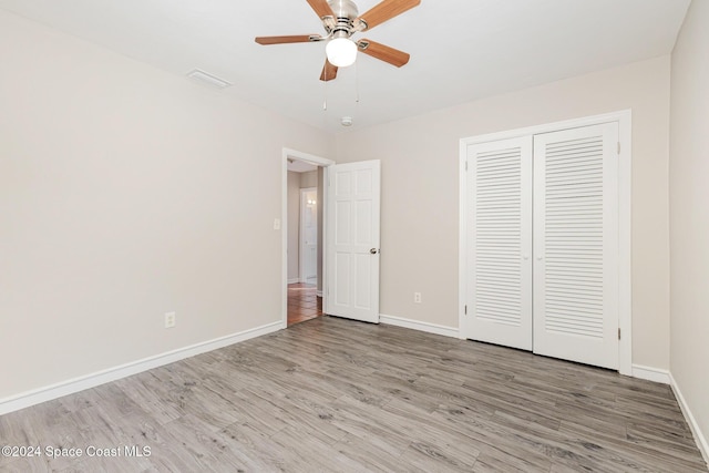 unfurnished bedroom with ceiling fan, a closet, and light wood-type flooring